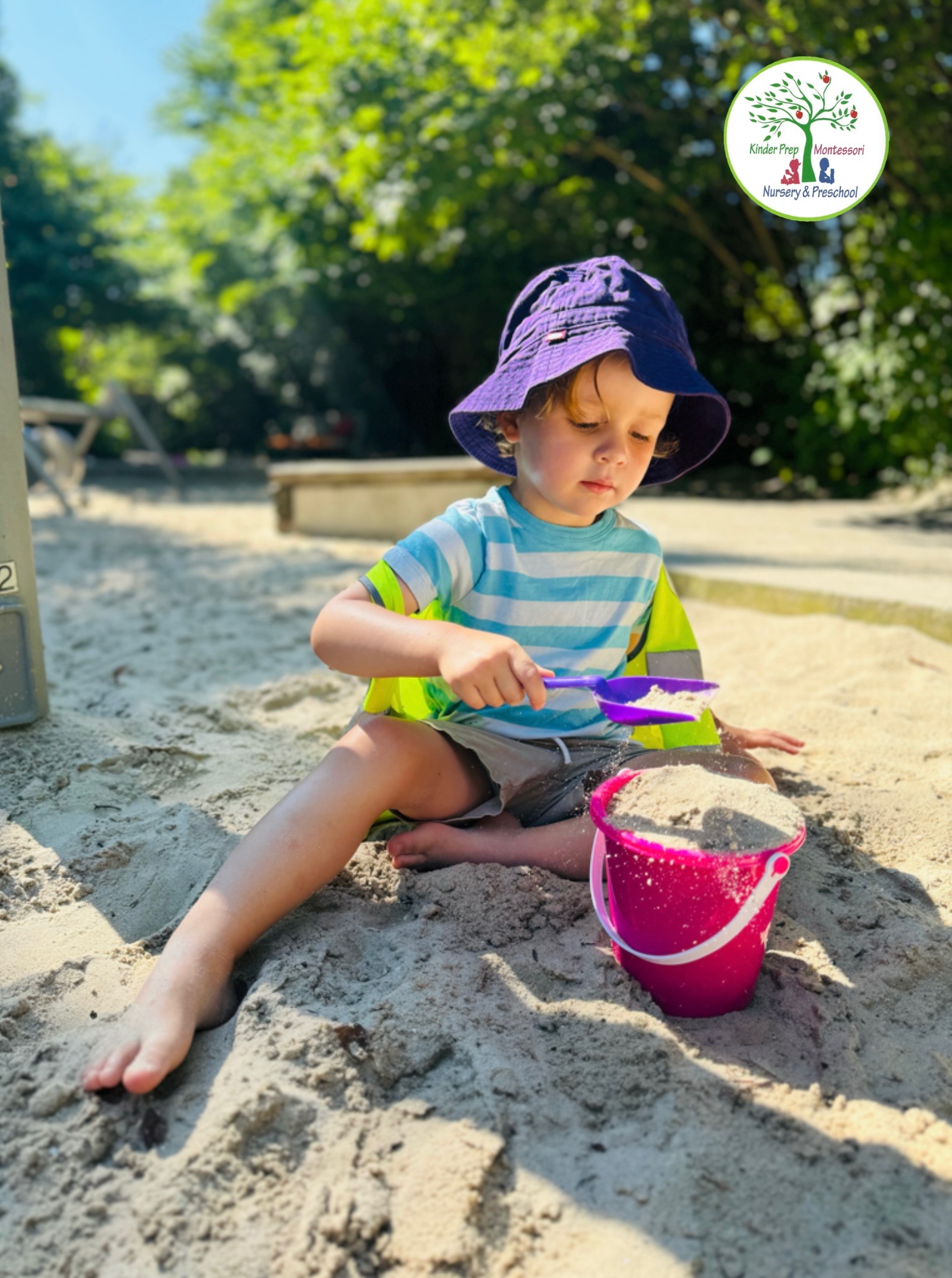 Child playing with sand toys and bucket at Brooklyn Bridge Park summer camp beach area